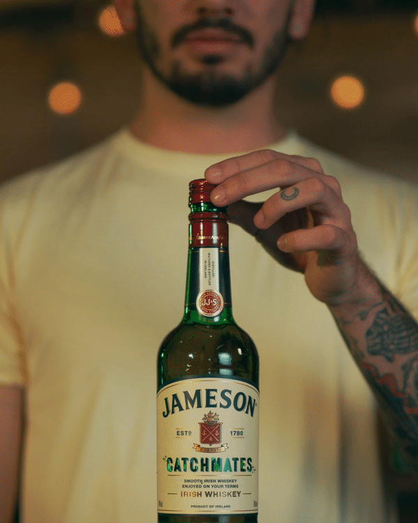 Glitter exploding from a bottle of Jameson Catchmates after a man removes the cap.